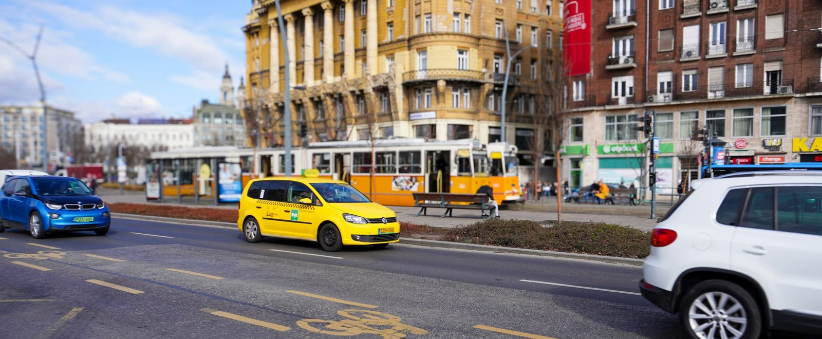 a yellow taxi cab driving down a street next to tall buildings